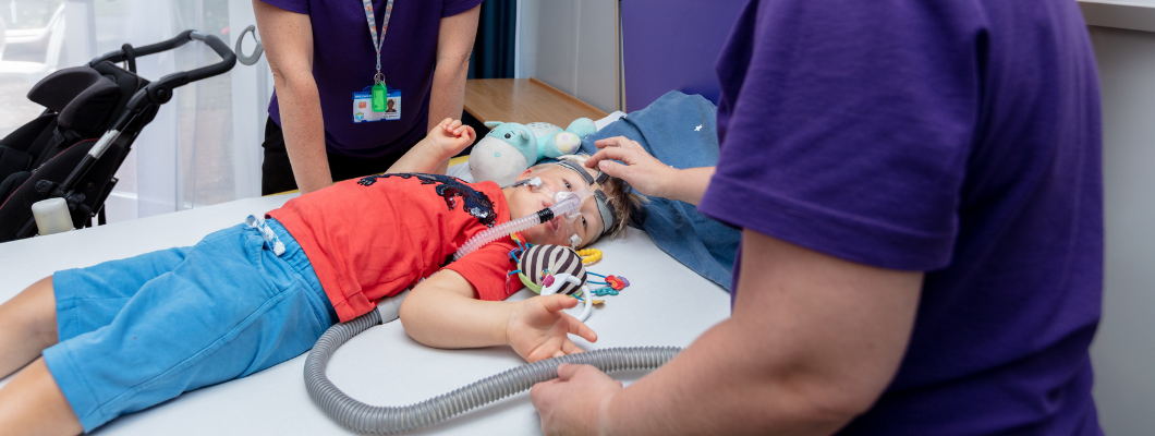 Little boy in bed with Bipap machine