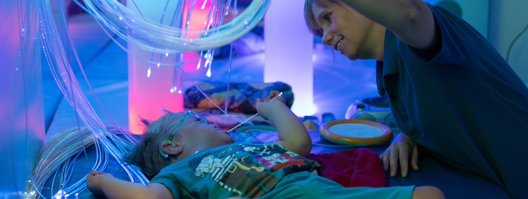 Little boy in sensory room at Little Havens with a health care assistant