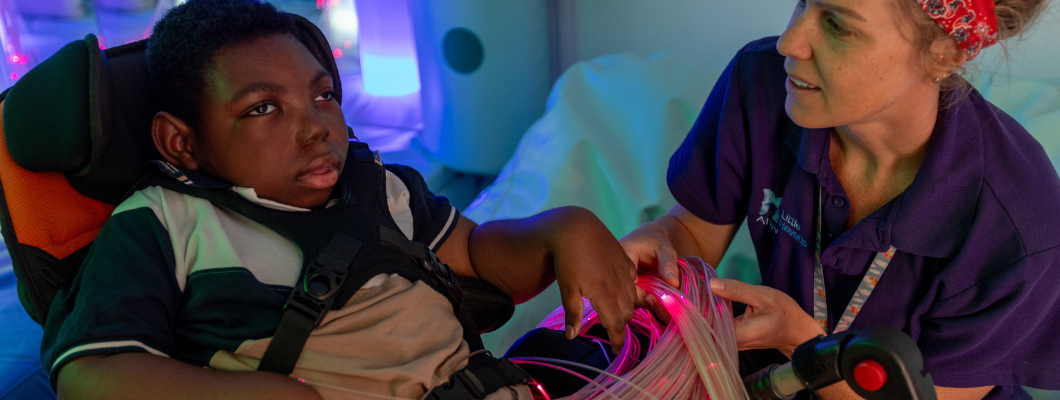 Little boy with health care assistant in the sensory room at Little Havens