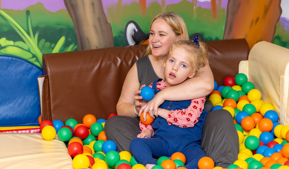 Lucy and her mum sat in ball pit at Little Havens