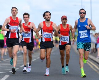 Group of 5 runners in a straight line running towards camera