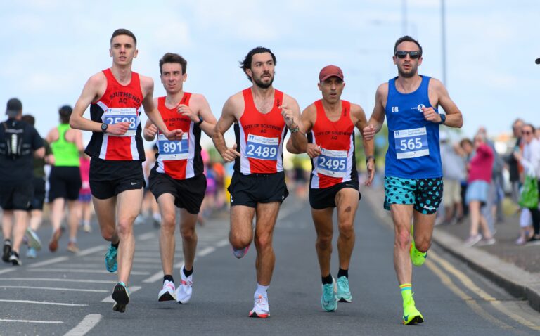 Group of 5 runners in a straight line running towards camera