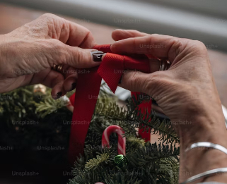A close up of hands creating a christmas wreath
