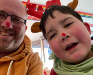 Archie and his dad with red paint on their noses to be like rudolph