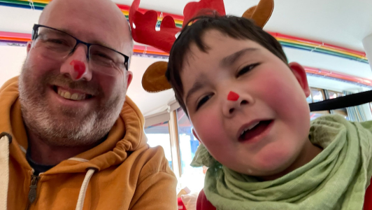 Archie and his dad with red paint on their noses to be like rudolph
