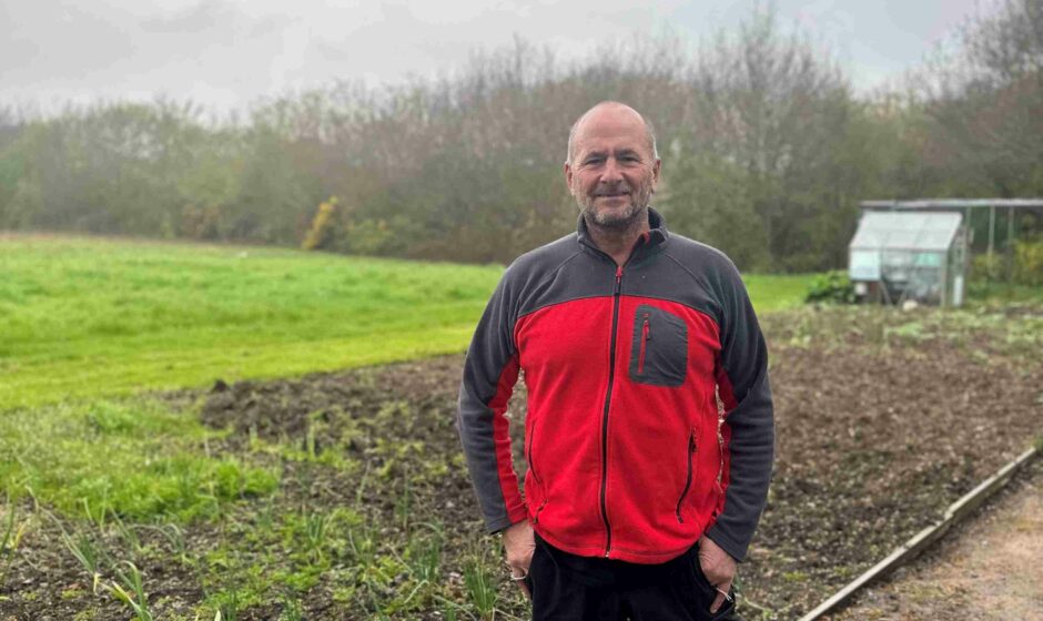 Volunteer Paul standing in front of an open field