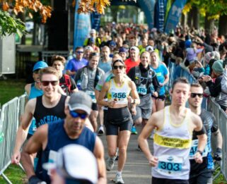 Runners racing through Central Park with autumnal trees either side