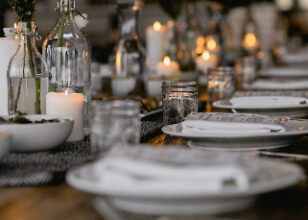 A dinner setting, with candles along the centre of the table