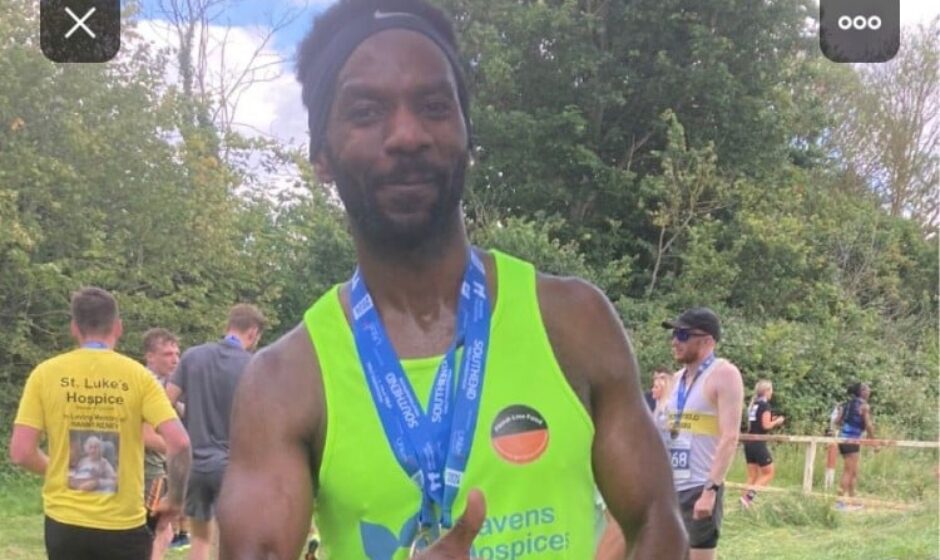 Theo stood after the race wearing a yellow running vest and his medal