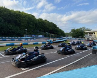 Go-Karts lined up on a track at the start of the charity race