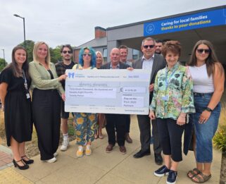 Businesses professionals and fundraisers for Havens Hospices standing outside Fair Havens holding a cheque.