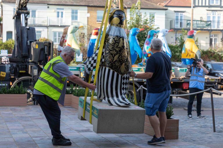 Large penguin sculpture being lifted