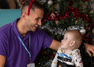 Child at Little Havens looking up to male staff carer