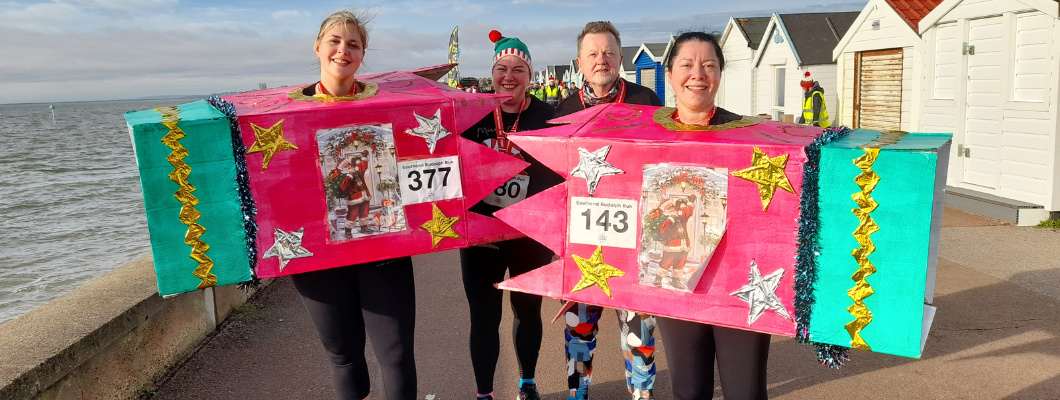 Two people at a fun run dressed as christmas crackers