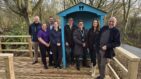 A group of men and women from the Knight Group standing around a new bench with representatives from Havens Hospices.