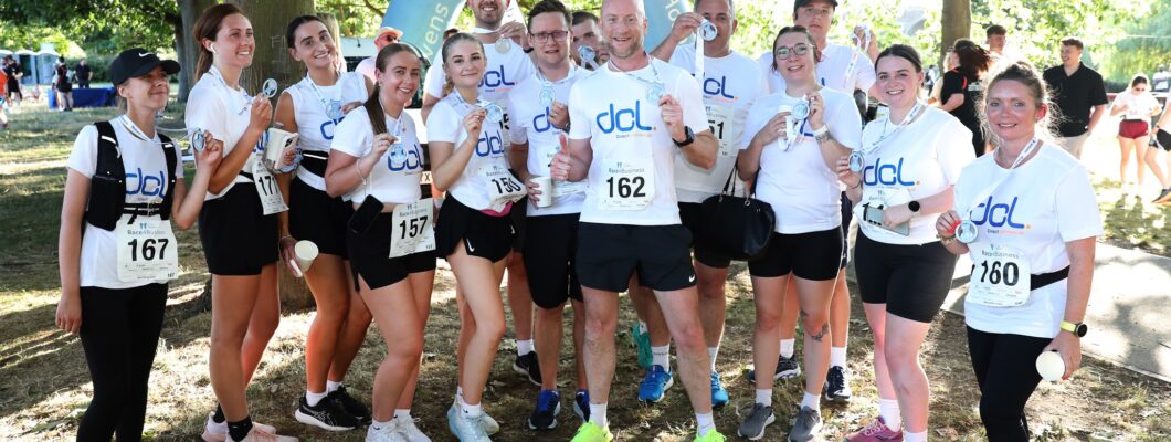 runners all wearing white tshirts with their company logo on the front grouped together smiling at camera