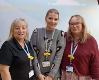 Three ladies from standing together smiling in Little Havens reception