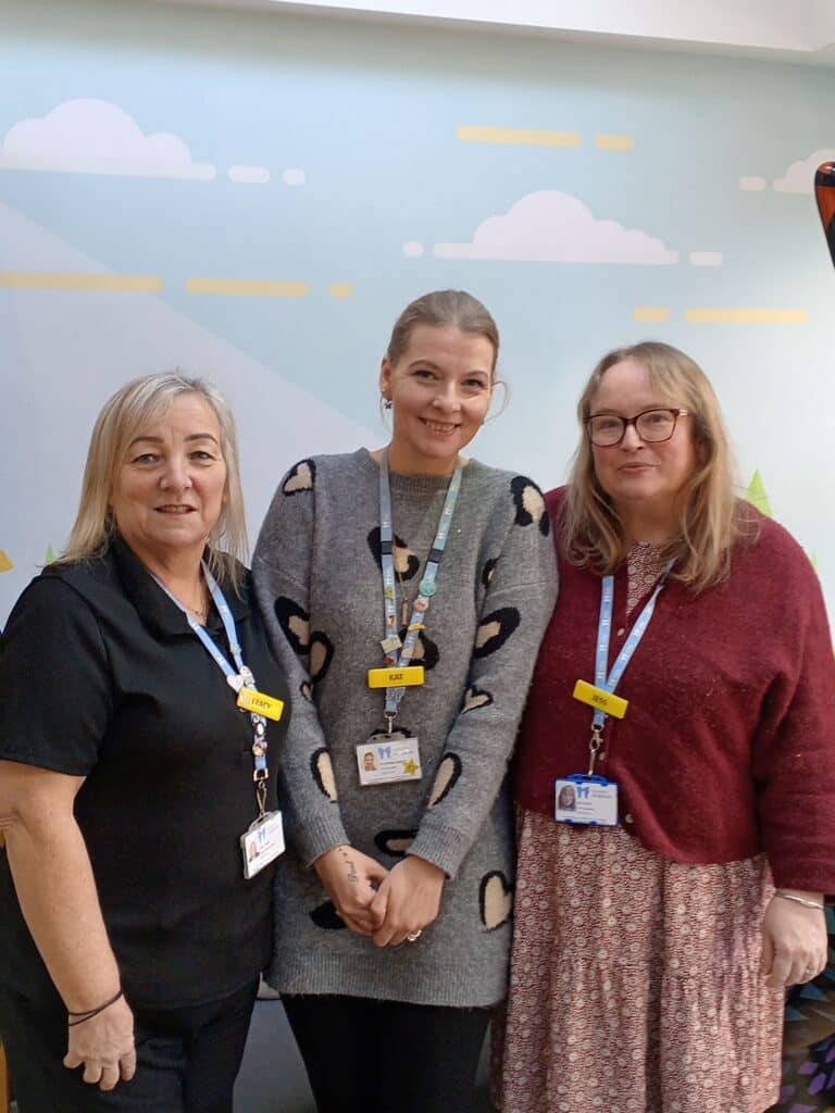 Three ladies from standing together smiling in Little Havens reception