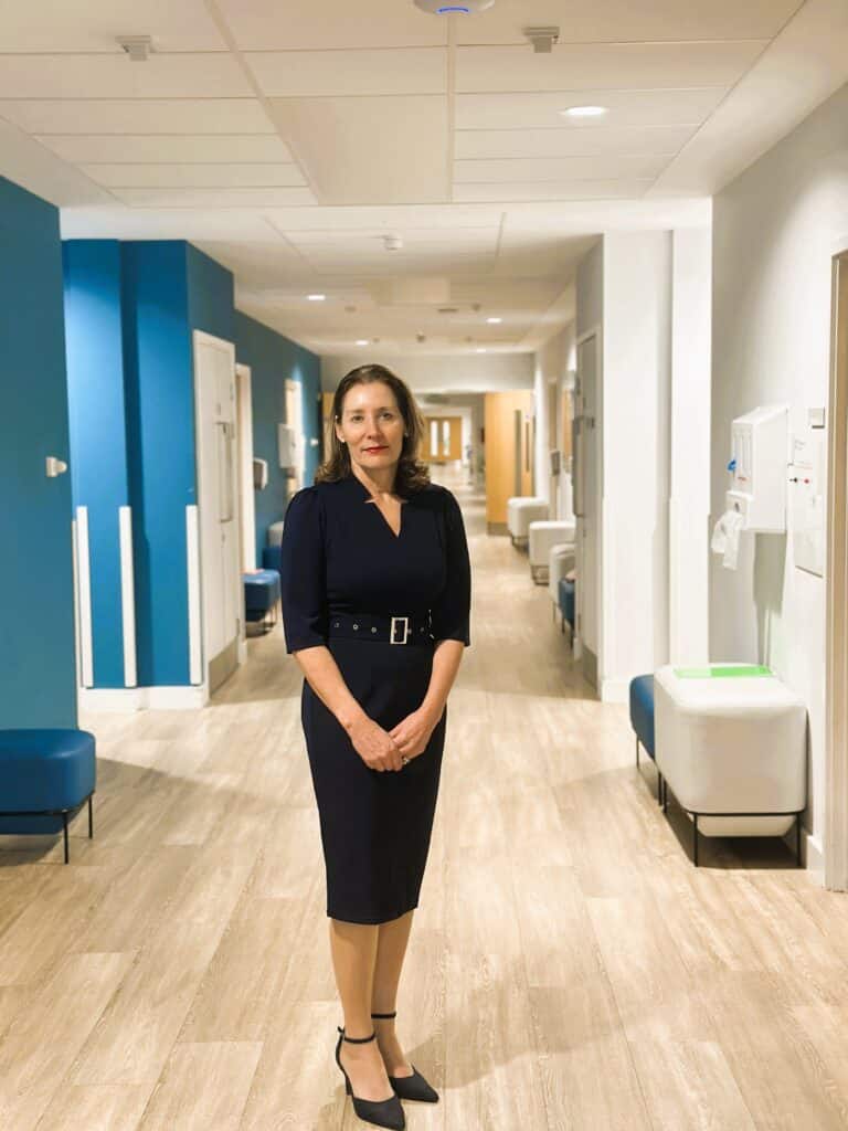 Louise Bryan standing in hospice corridor