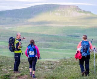 Four trekkers standing in front of a mountainous view
