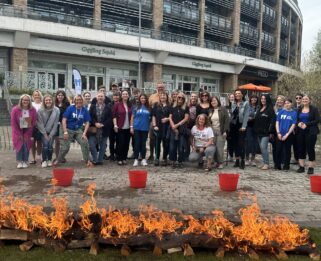 Large group of Fire Walk Supporters standing behind a line of flames in the Bond Street Bowl Chelmsford