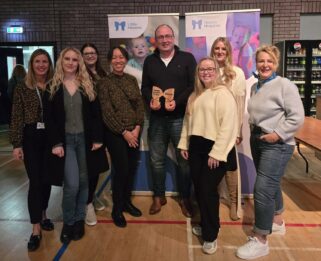 Team from Impact HR holding their Butterfly shaped wooden trophy after winning on the night of the quiz