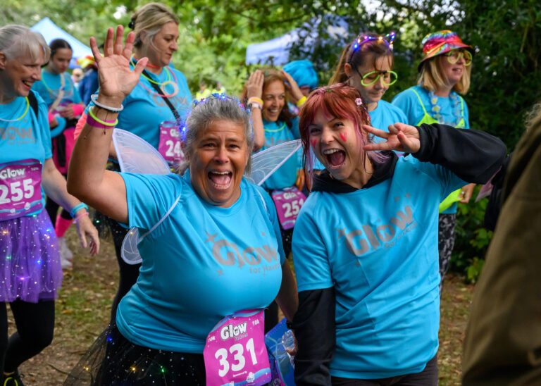 Two women dressed in neon clothes at the Glow for Havens event.