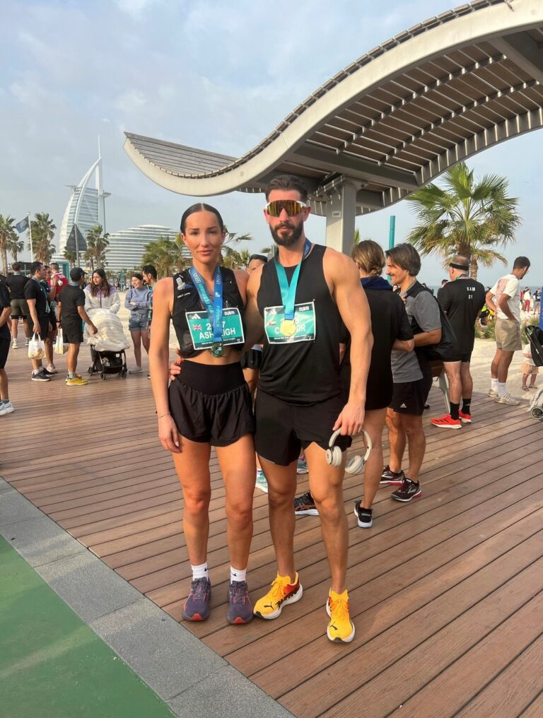 Man and women posing with their medal at Dubai Marathon