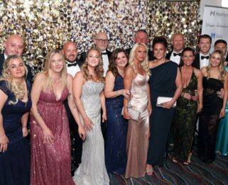 Group photo of men and women in black tie.
