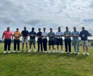Men standing with golf clubs.