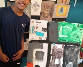 Young boy standing next to his artwork at the previous Leigh Art Trail