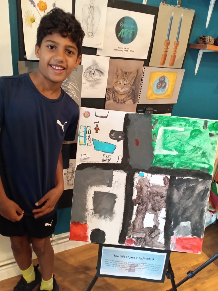 Young boy standing next to his artwork at the previous Leigh Art Trail