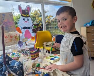 Ellis sat doing crafts at Little Havens with easter decorations around him