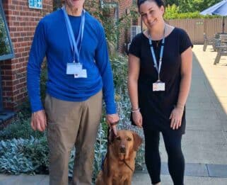 Andrew standing in Fair Haven's garden holding his dog's, Rosa, lead next to Lizzie
