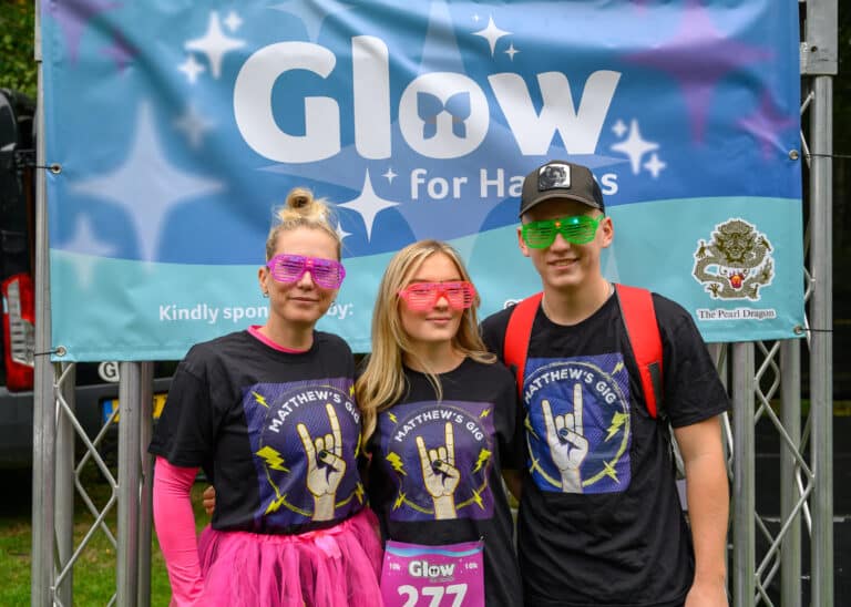 Two women and a man in glowing outfits.