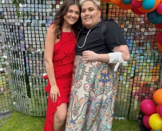 Two women in front of a balloon arch