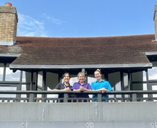 Three Care Team members on the balcony at Little Havens in front of newly renovated windows