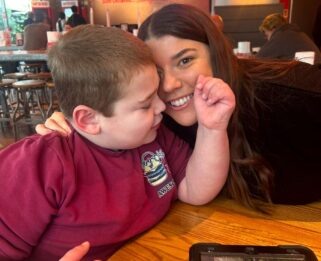 Young boy and his mum smiling in a resturant