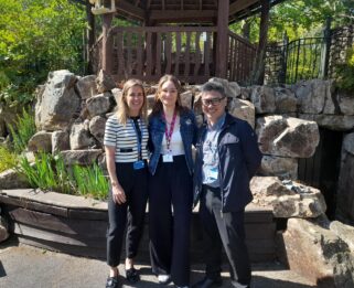 Two women and a man standing in the Little Havens garden smiling
