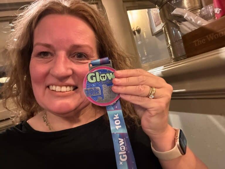 A lady smiling with a Glow for Havens medal