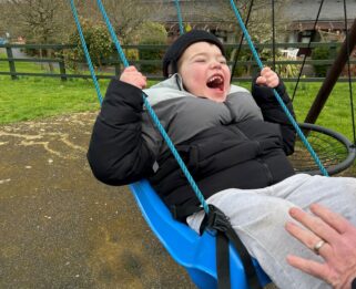 Boy laughing in a swing.